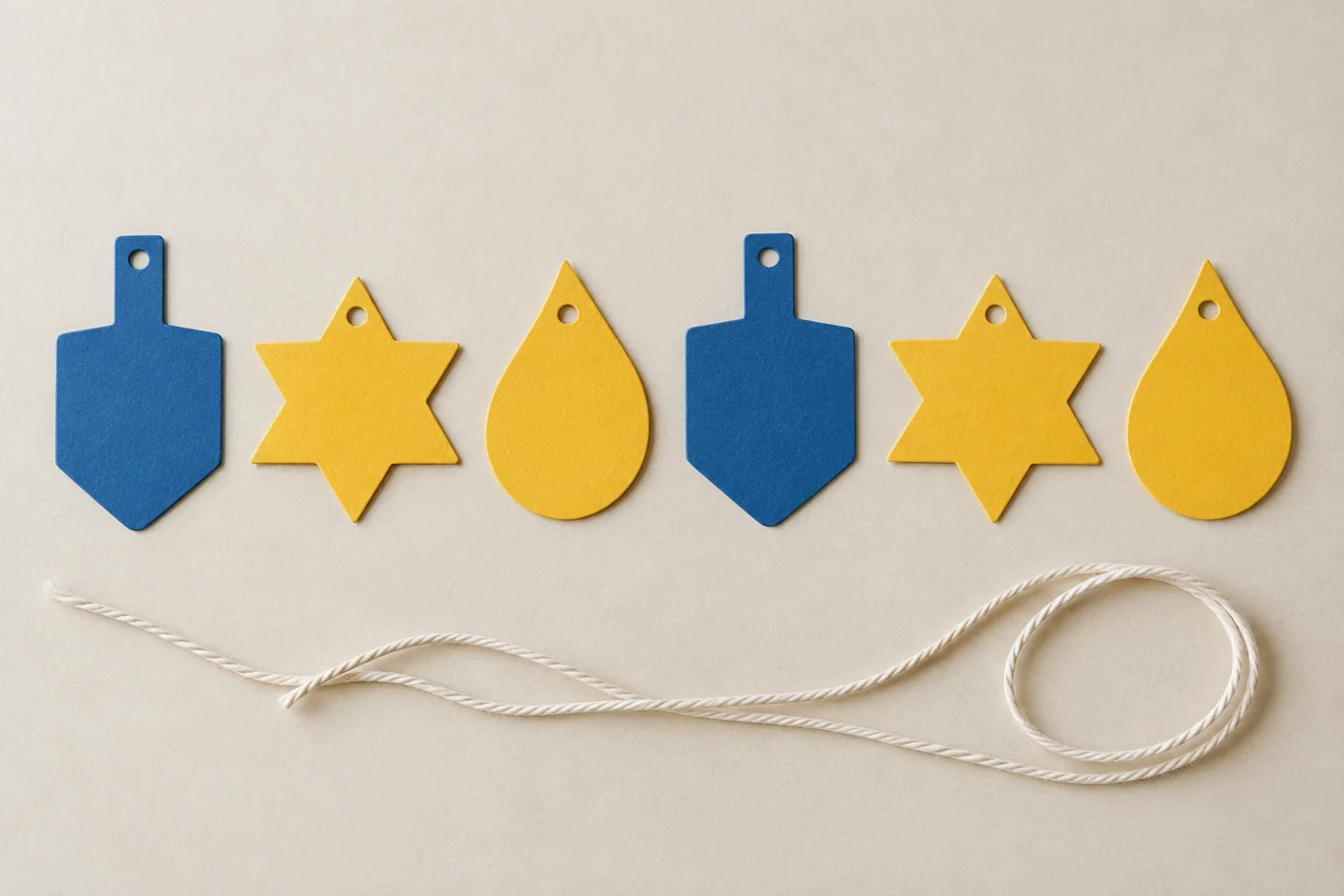 Two dreidel, two star and two teardrop shapes ready for threading