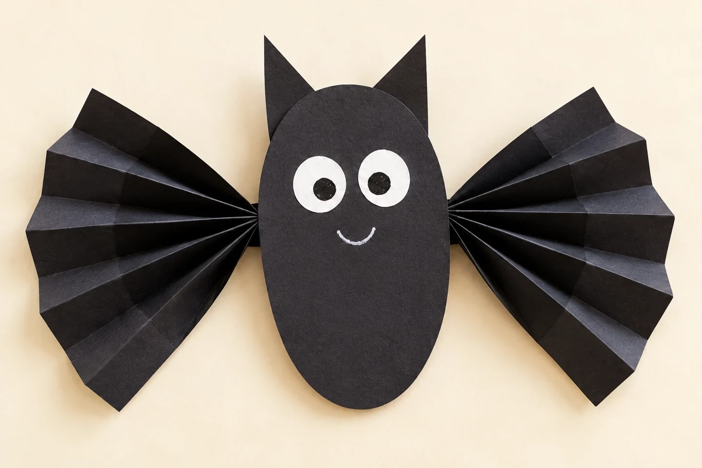 The completed paper bat with two balanced accordion wings and a friendly face.