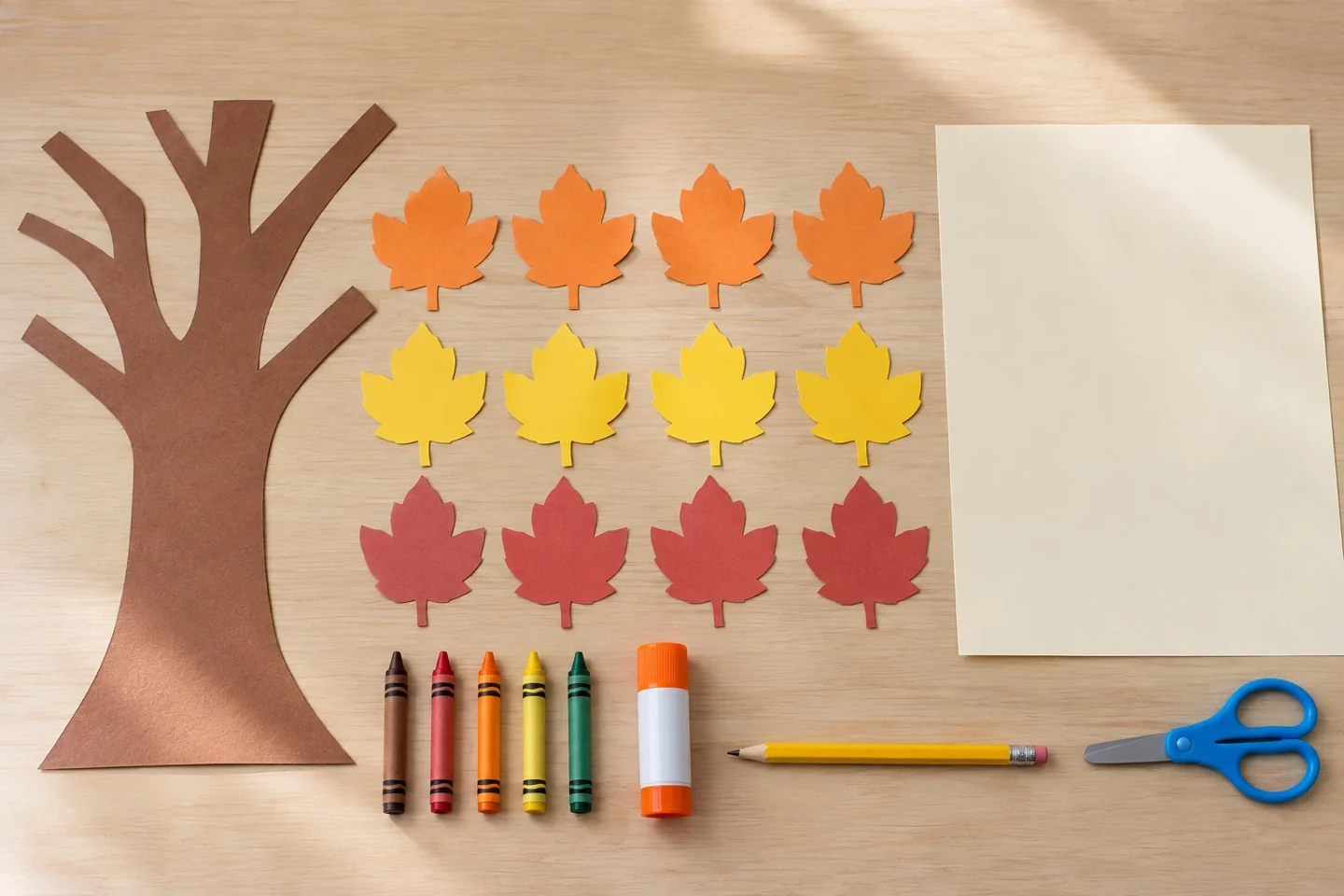 Brown paper trunk, twelve colorful leaves, background paper, crayons, scissors and glue